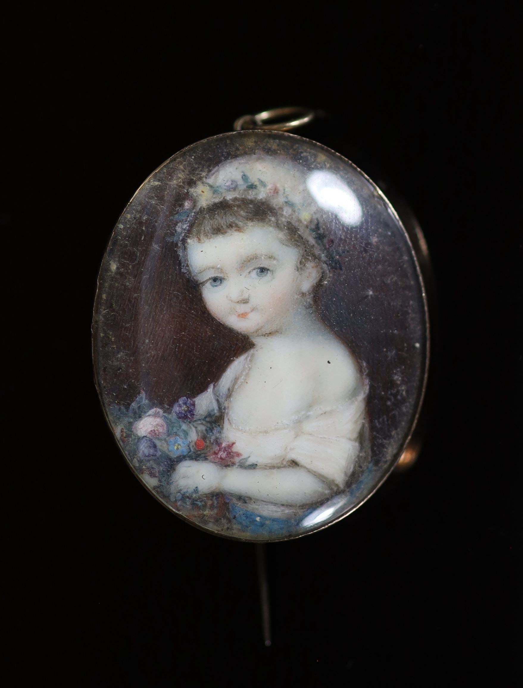 A Georgian miniature oval watercolour portrait of a child with flowers, in gold pendant brooch mount